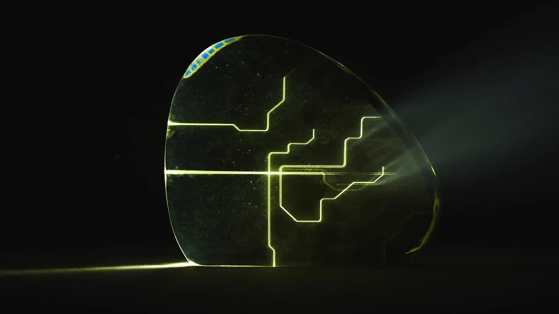 Dark glass monolith with green light traces running through it