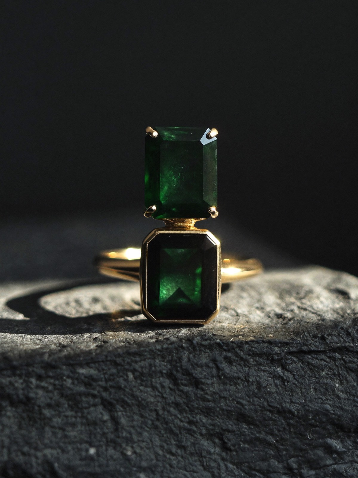 Emerald and gold ring under a beam of light