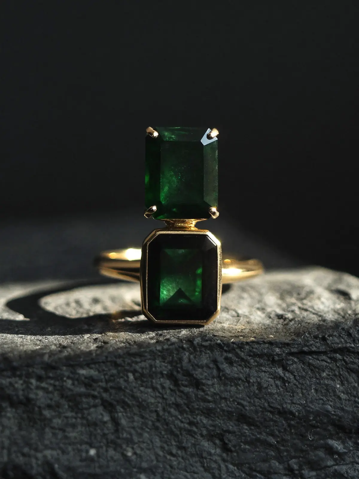 Emerald and gold ring under a beam of light