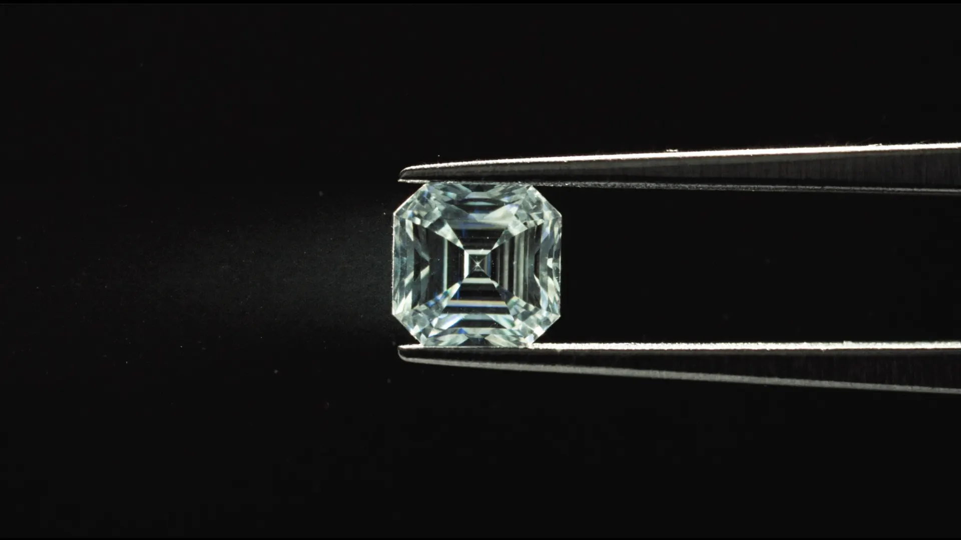 Emerald-cut diamond held in jeweller's tweezers