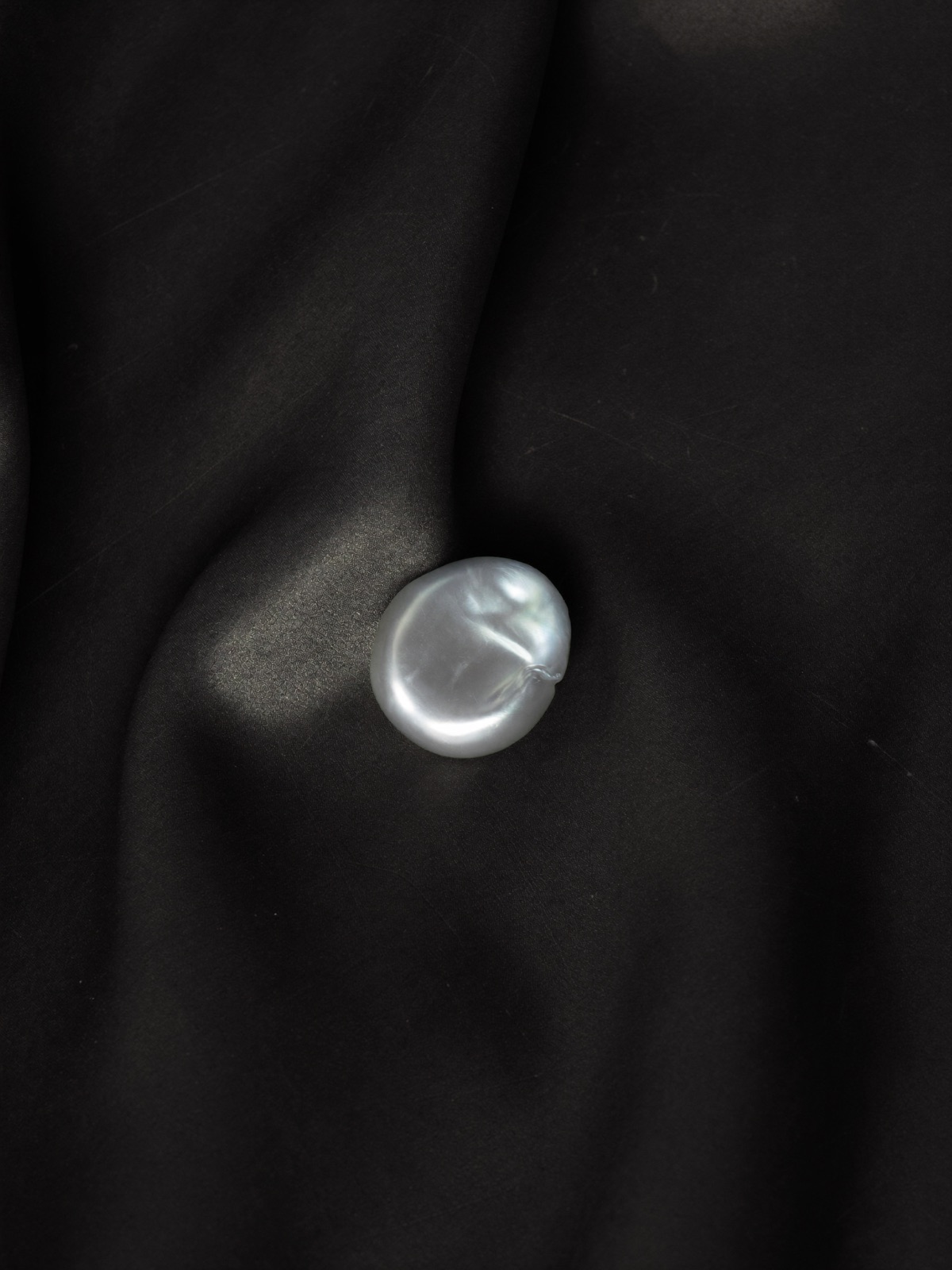Baroque pearl on dark silk