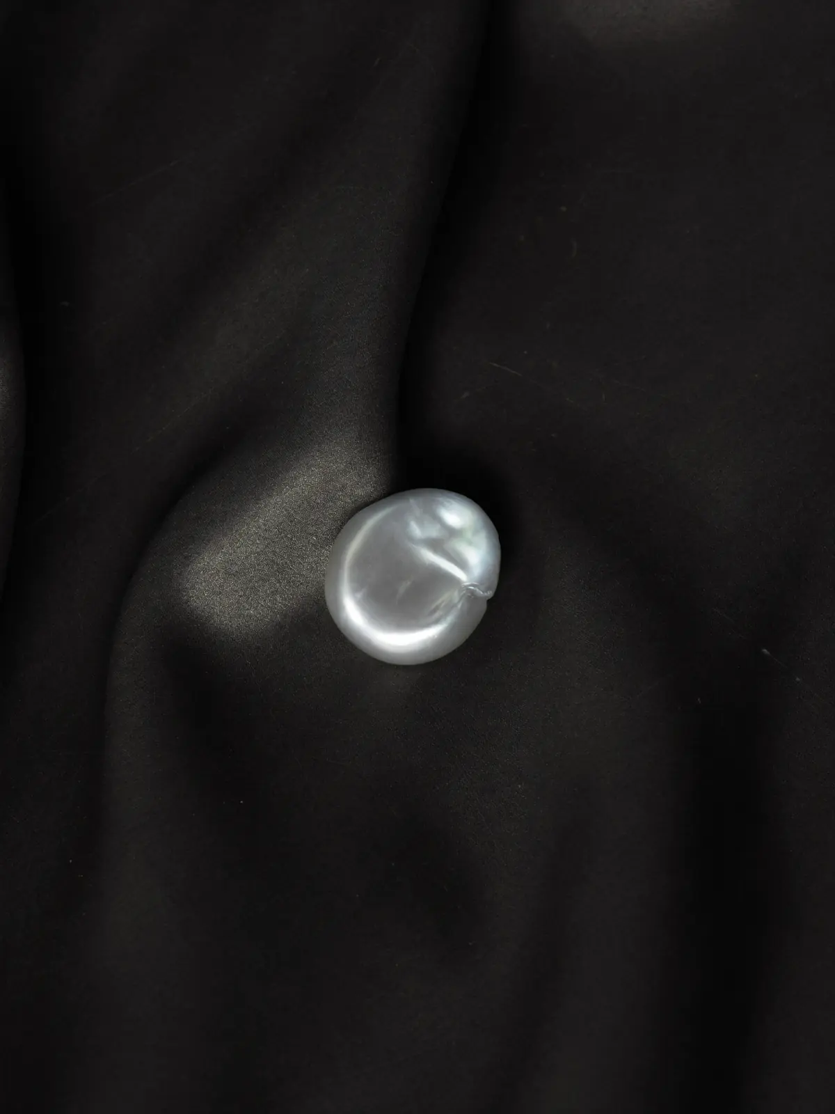 Baroque pearl on dark silk
